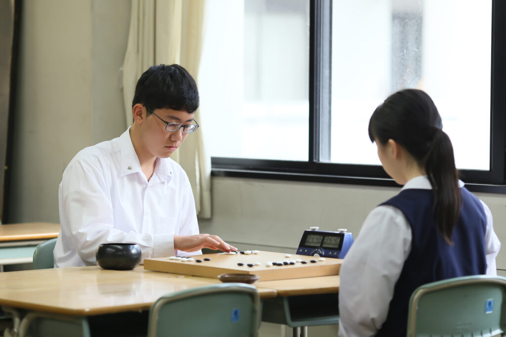 囲碁をしている男女の高校生