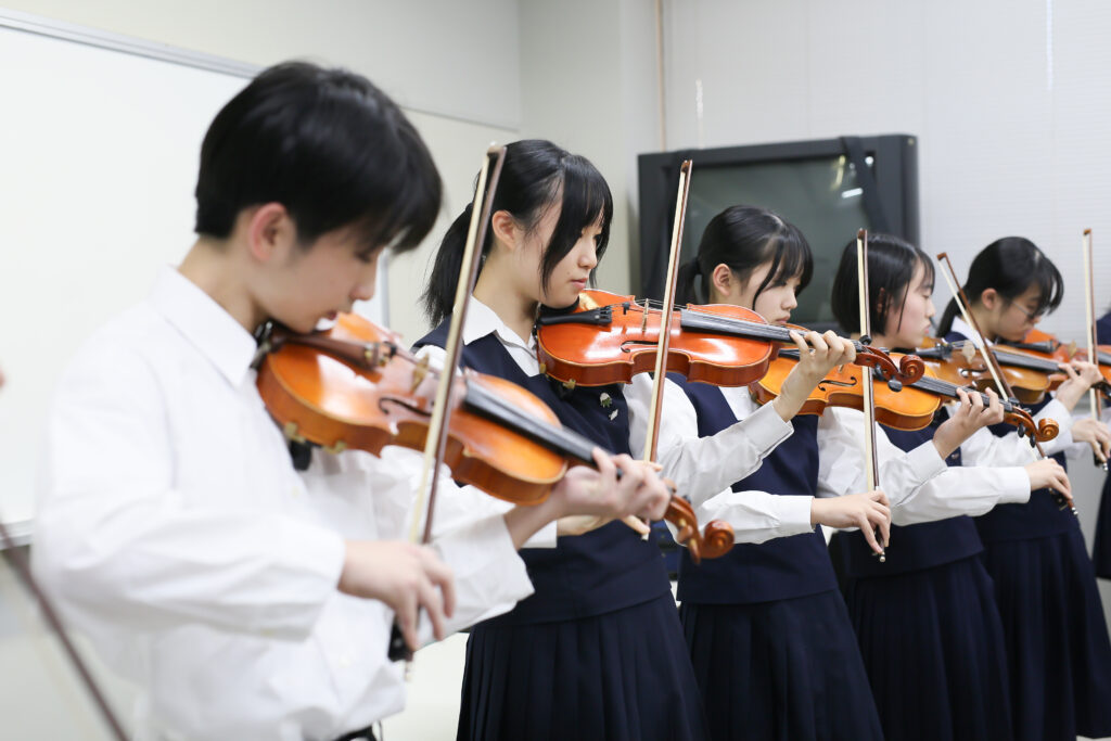 バイオリンの練習をする高校生たち